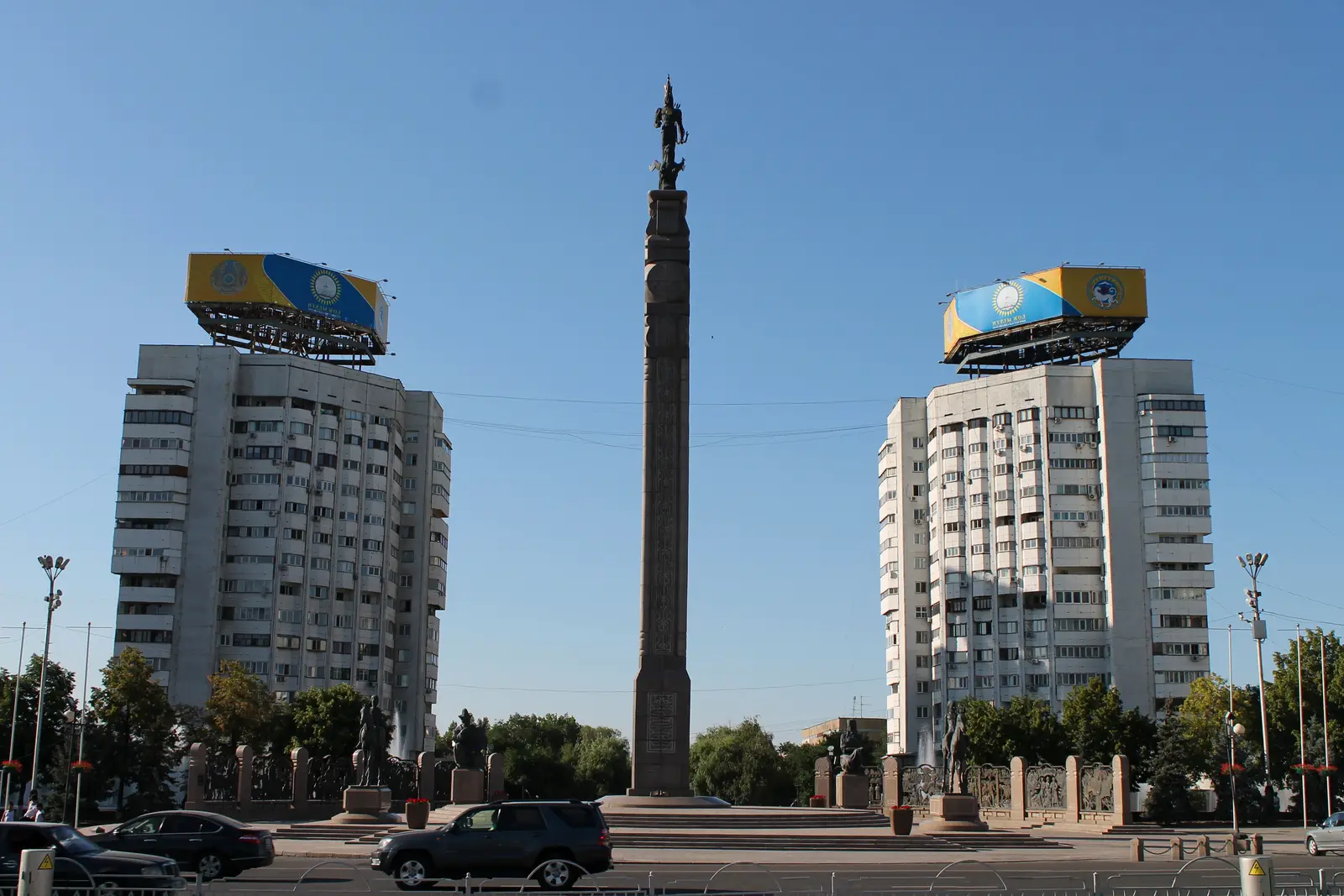 The Independence Monument column on Republic Square in Almaty, between two tower blocks