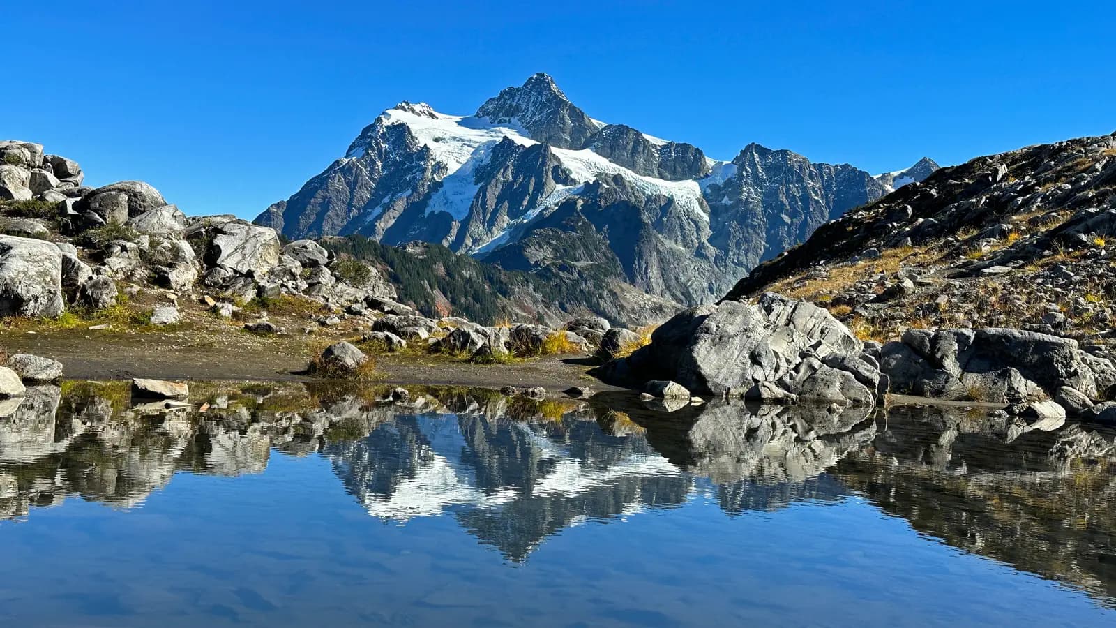 Mount Shuksan reflected in a small tarn among granite boulders at Artist Point