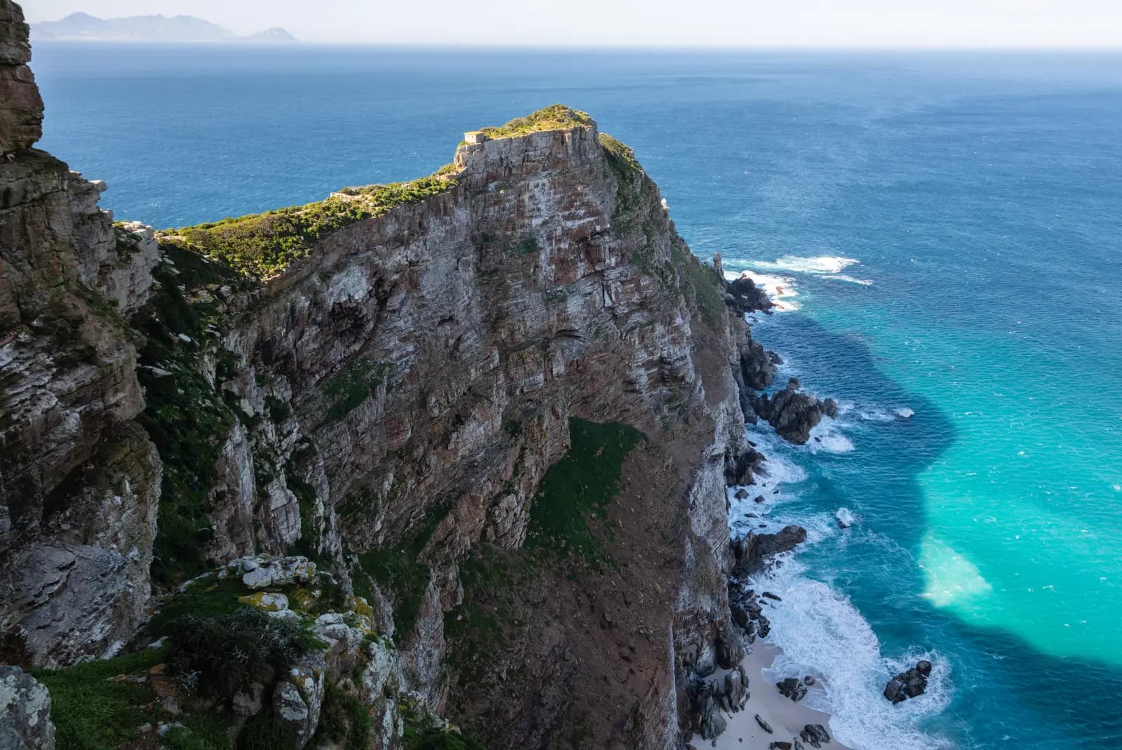 The sheer sandstone cliffs of Cape Point above turquoise water