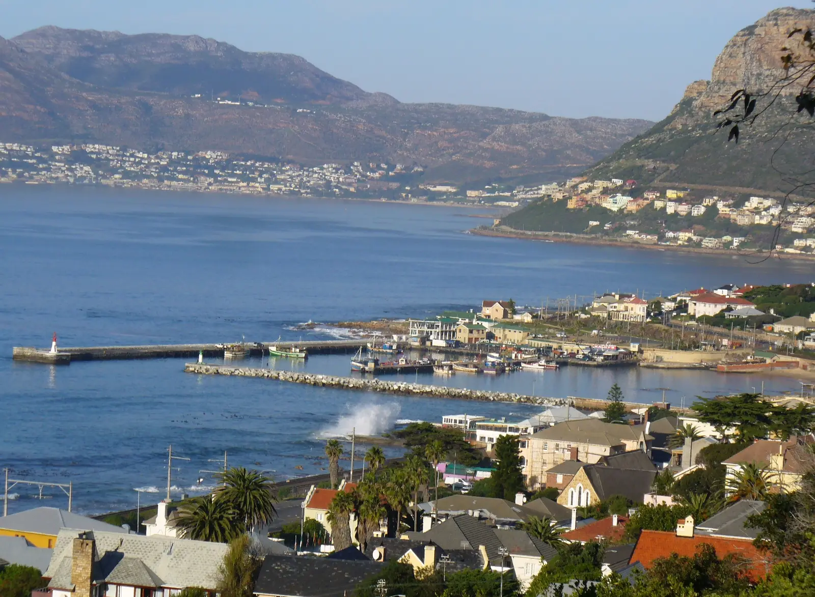 Kalk Bay harbour and its breakwater on False Bay, with Fish Hoek and the mountains behind