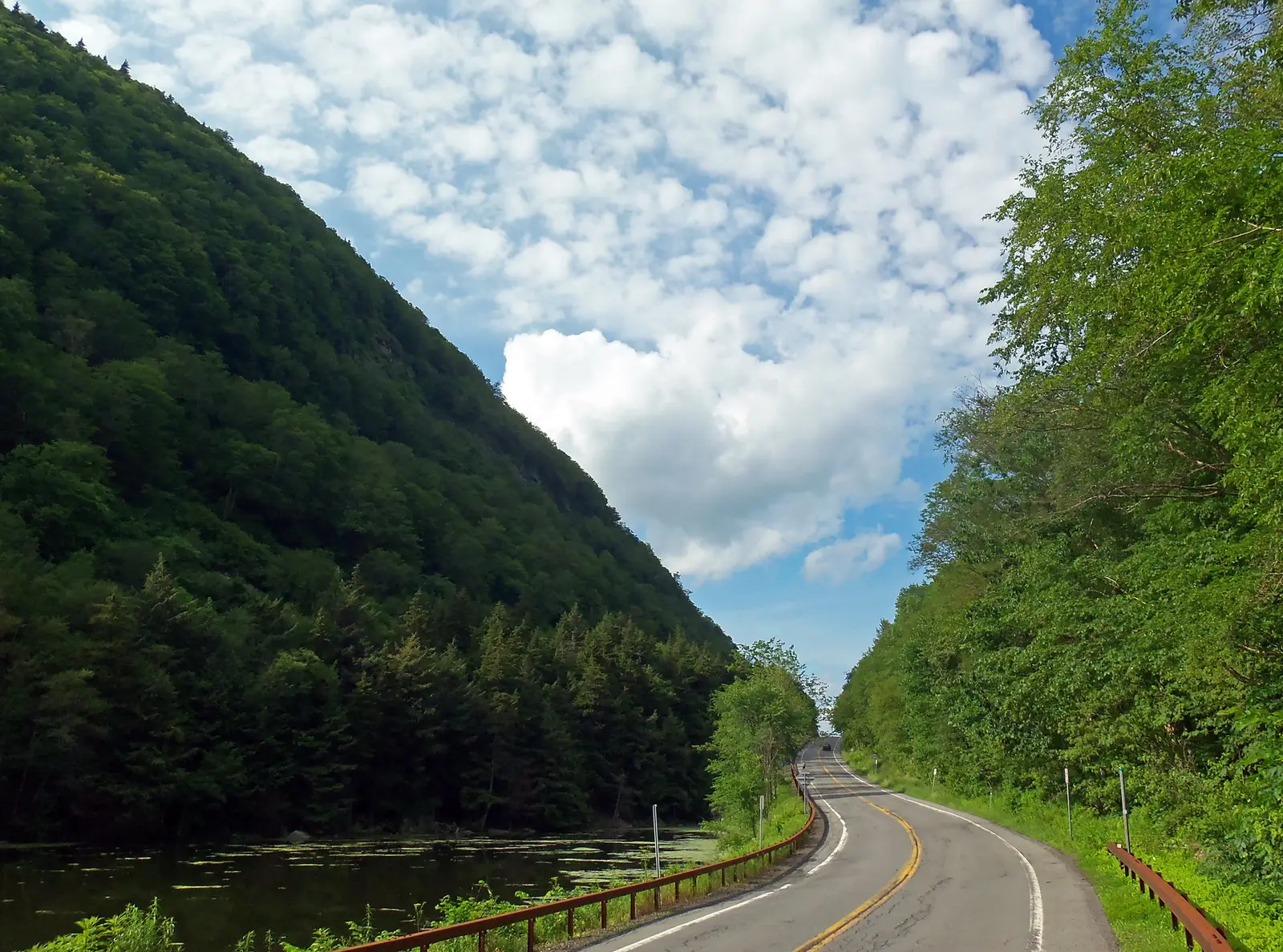 Route 214 curving past Notch Lake between steep forested mountainsides in Stony Clove Notch
