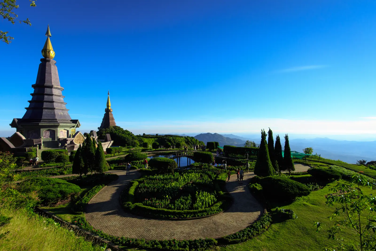 The two royal pagodas above formal gardens, with blue hills fading into the distance