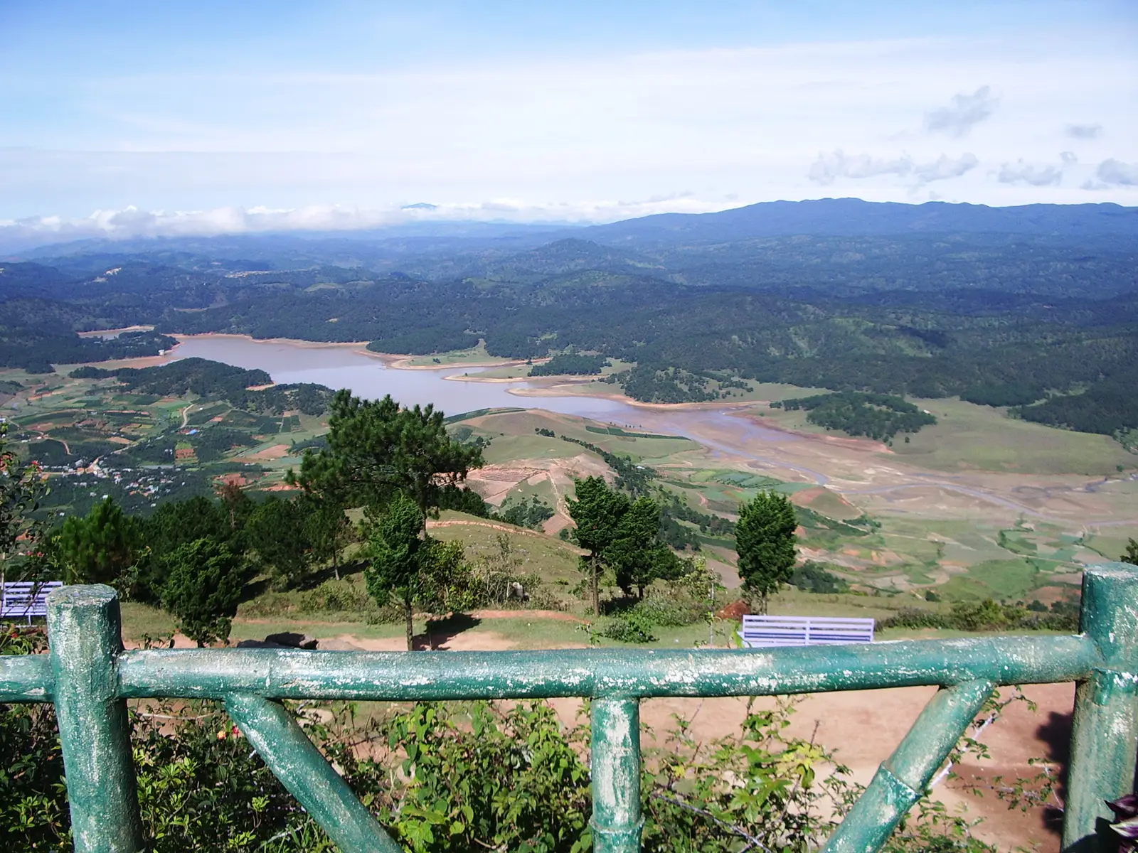 A reservoir and farmland spread below the viewing platform on Langbiang
