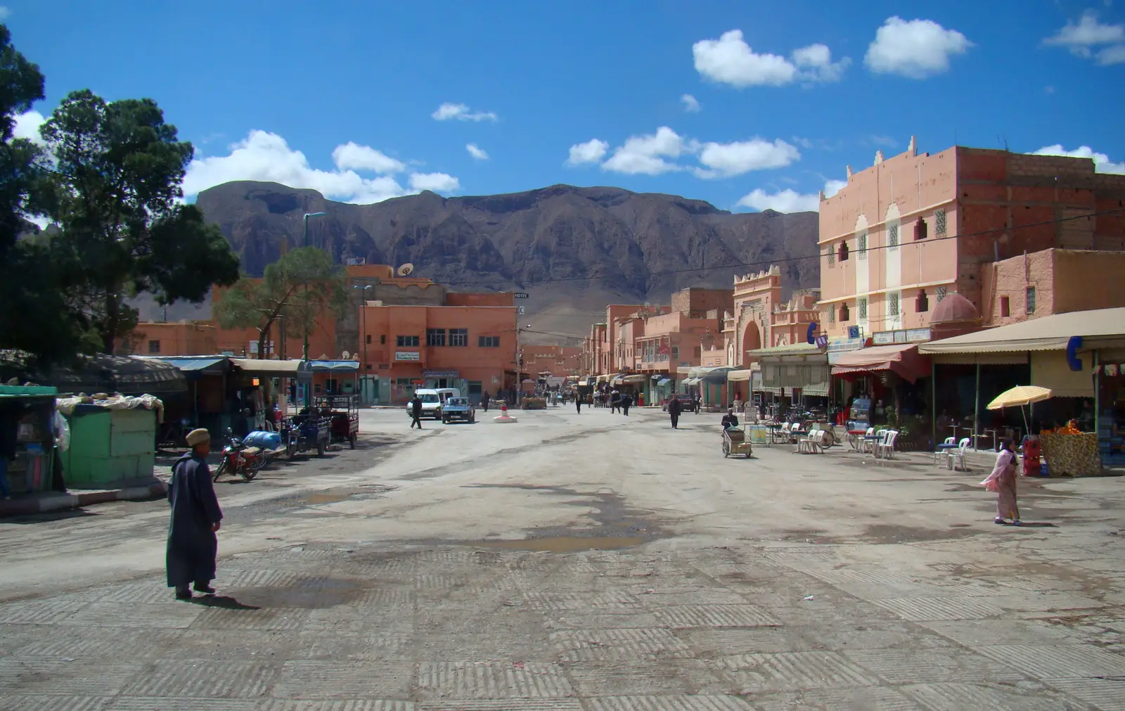 The wide main street of Rich lined with pink and ochre buildings, with bare mountains behind under a blue sky
