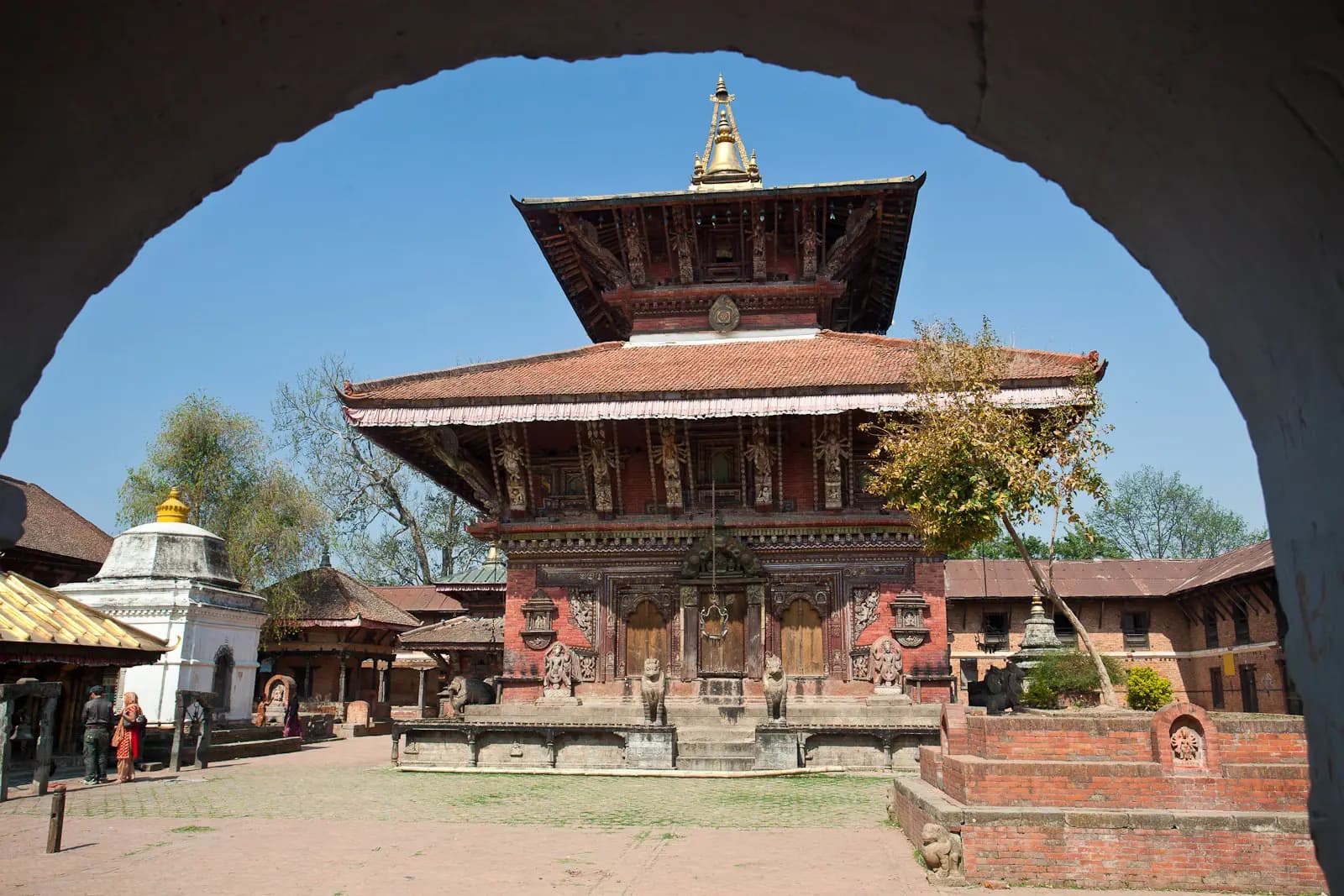 The two-tiered Changunarayan Temple framed by a brick archway