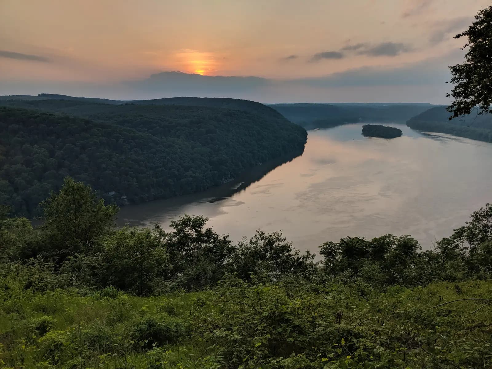 Sunset over Lake Aldred from the Pinnacle Overlook, with wooded hills falling to the river and a small island in the distance