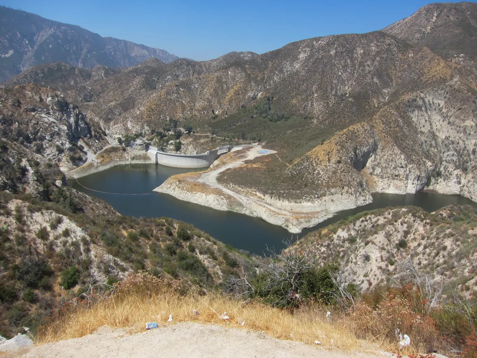 Big Tujunga Dam and its reservoir in a steep, dry canyon, seen from the overlook