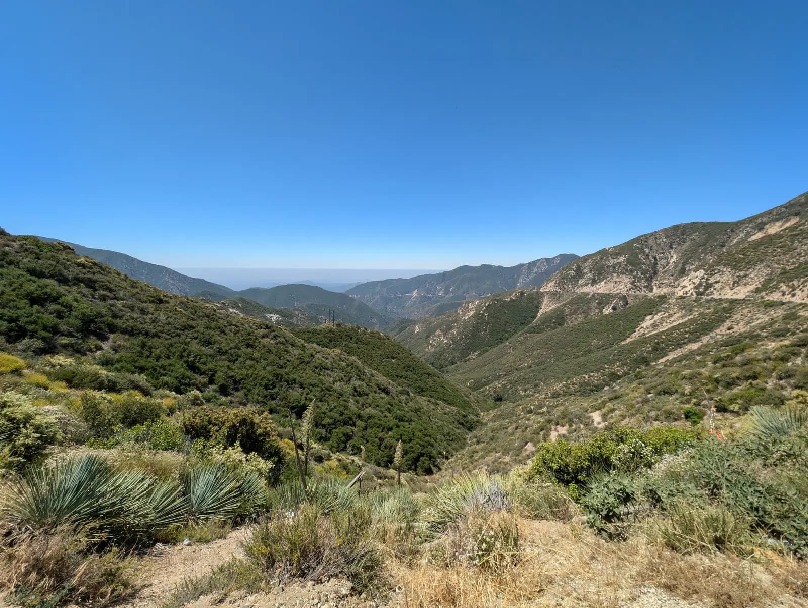Chaparral-covered canyon falling away towards the hazy lowlands, seen from the Angeles Crest Highway near Clear Creek