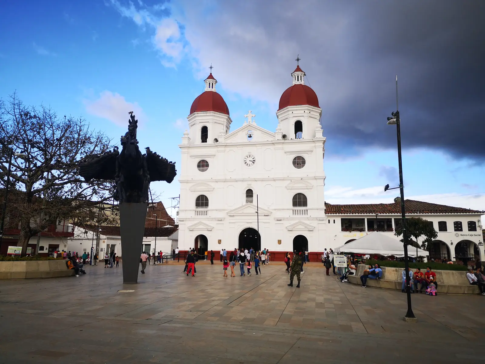 The white Concatedral de San Nicolás with red domes, seen across the Parque de la Libertad in Rionegro