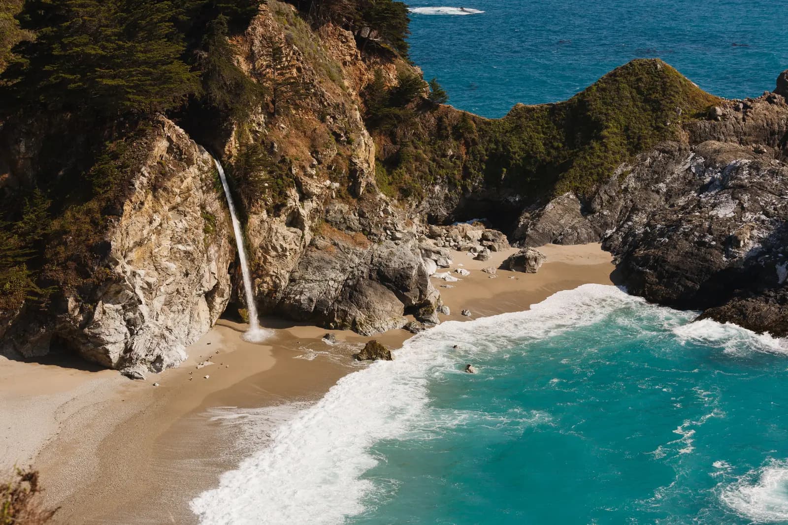 McWay Falls dropping from a cliff onto the beach of a turquoise cove