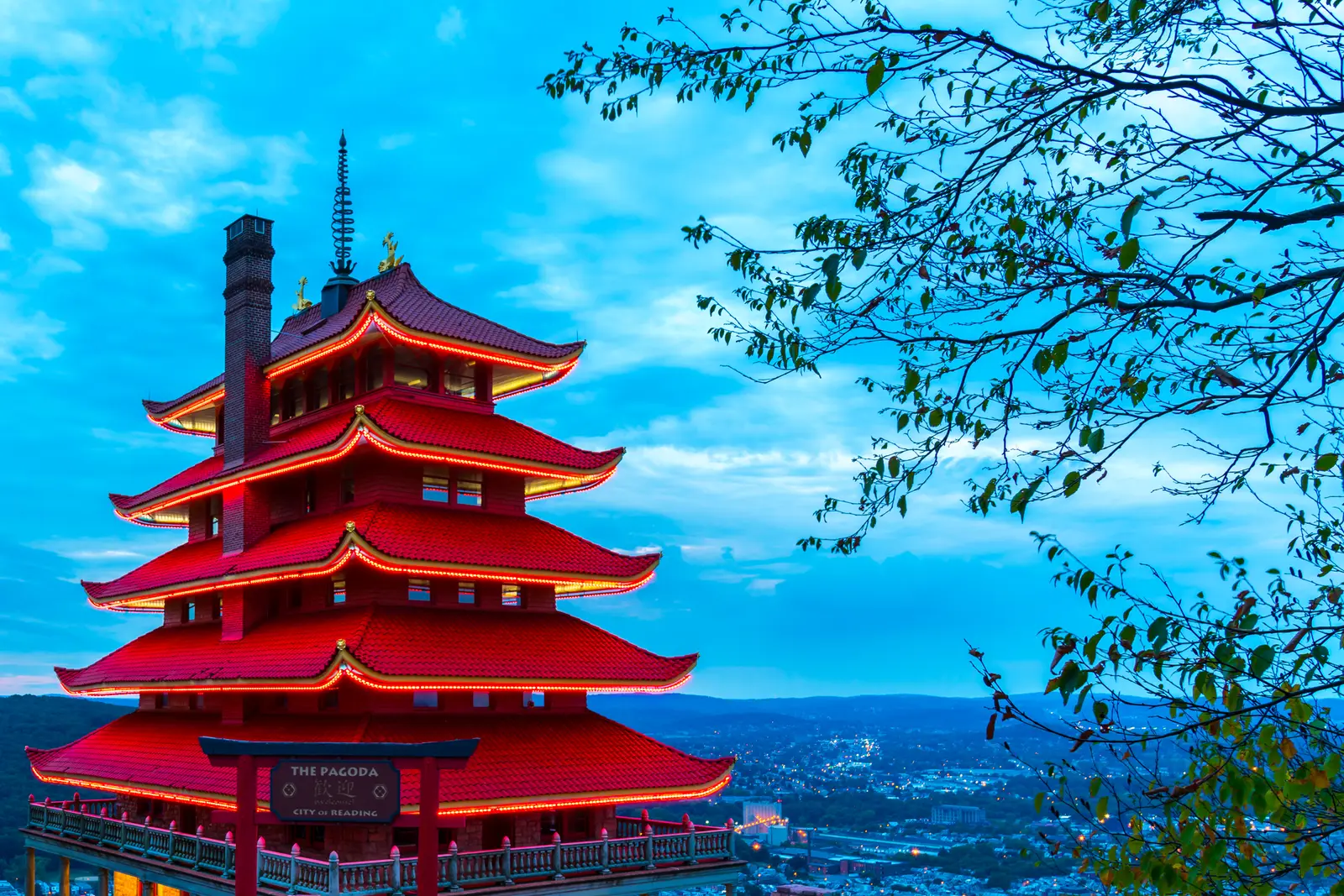 The red, seven-tiered Reading Pagoda against a blue sky, with the city below to the right