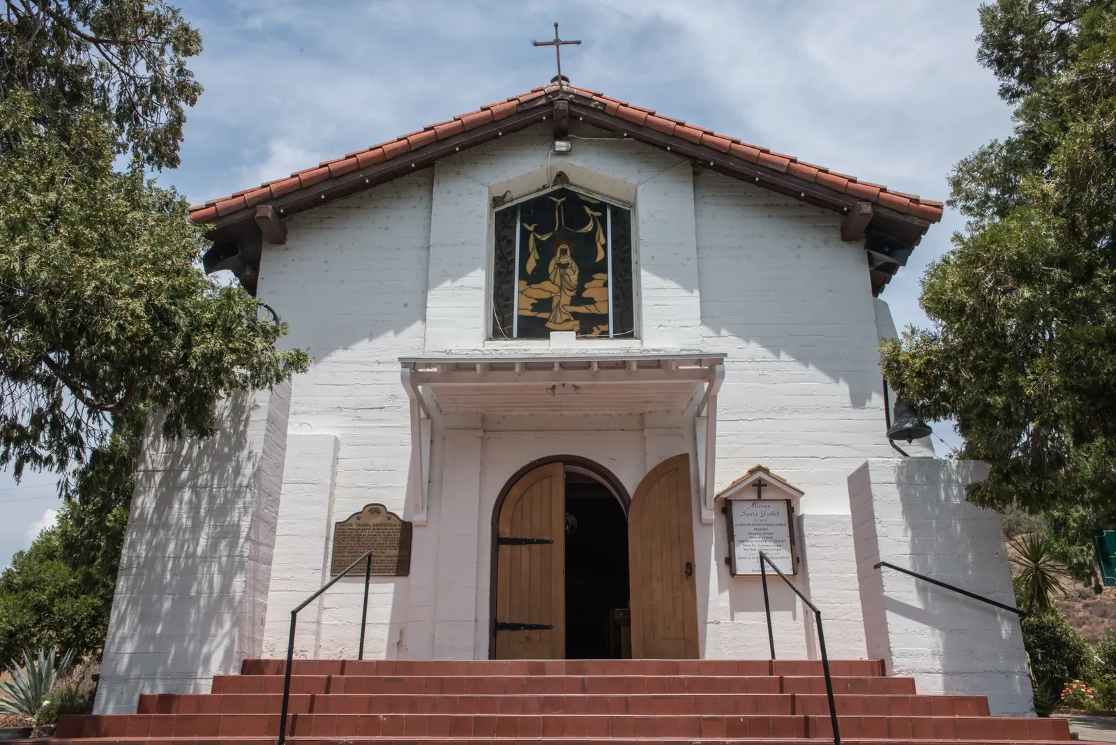 The whitewashed front of the Mission Santa Ysabel chapel with its tiled roof and red steps