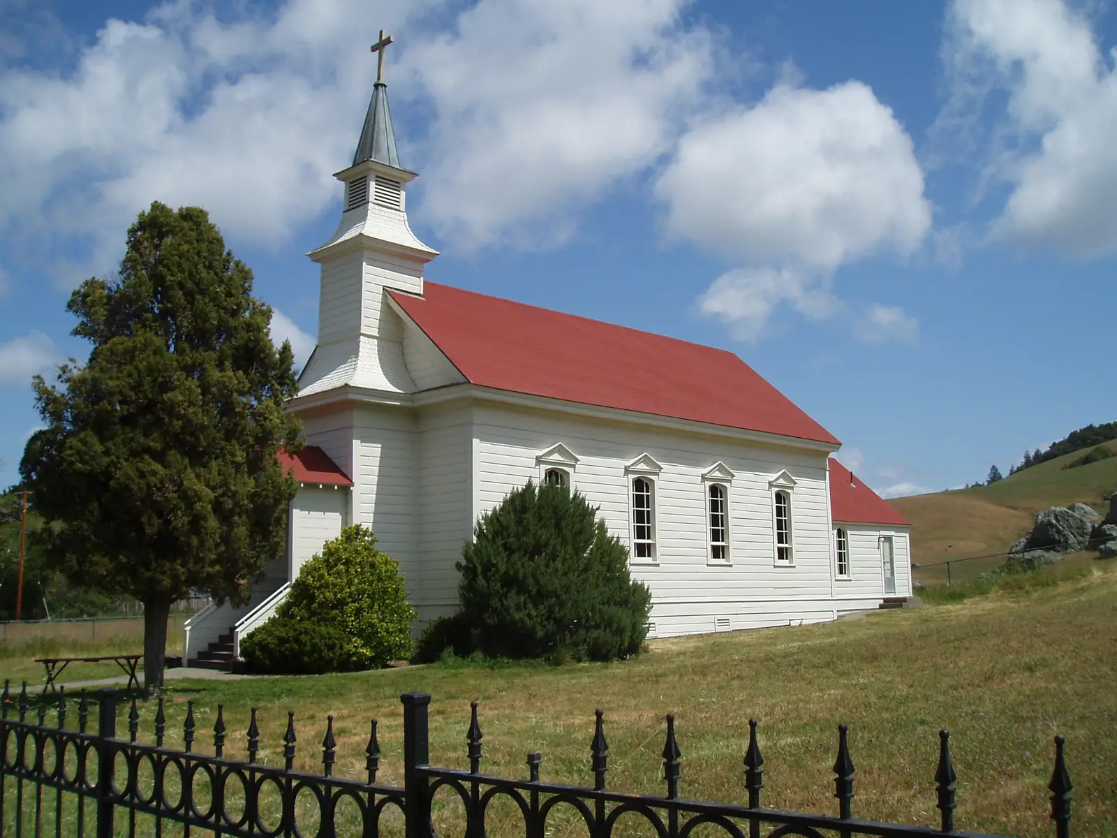 St. Mary's Church in Nicasio, a white timber church with a red roof and steeple, beside a field