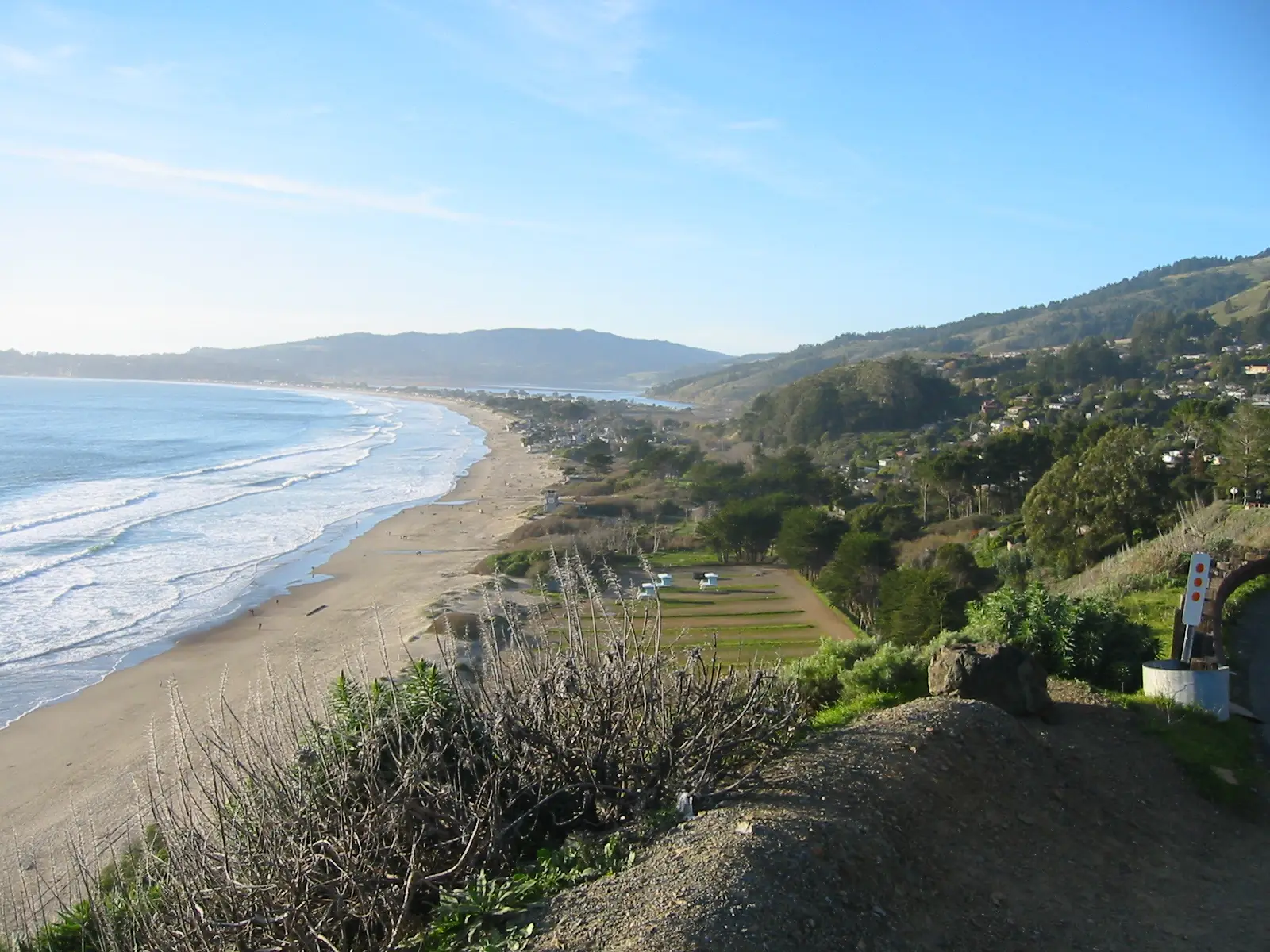 Stinson Beach curving north below the village and the wooded slopes of Bolinas Ridge