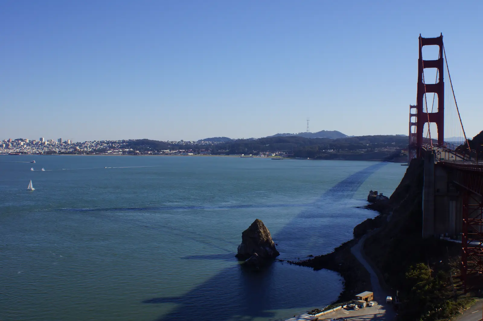 The north tower of the Golden Gate Bridge and a rock stack in the strait, with San Francisco across the water