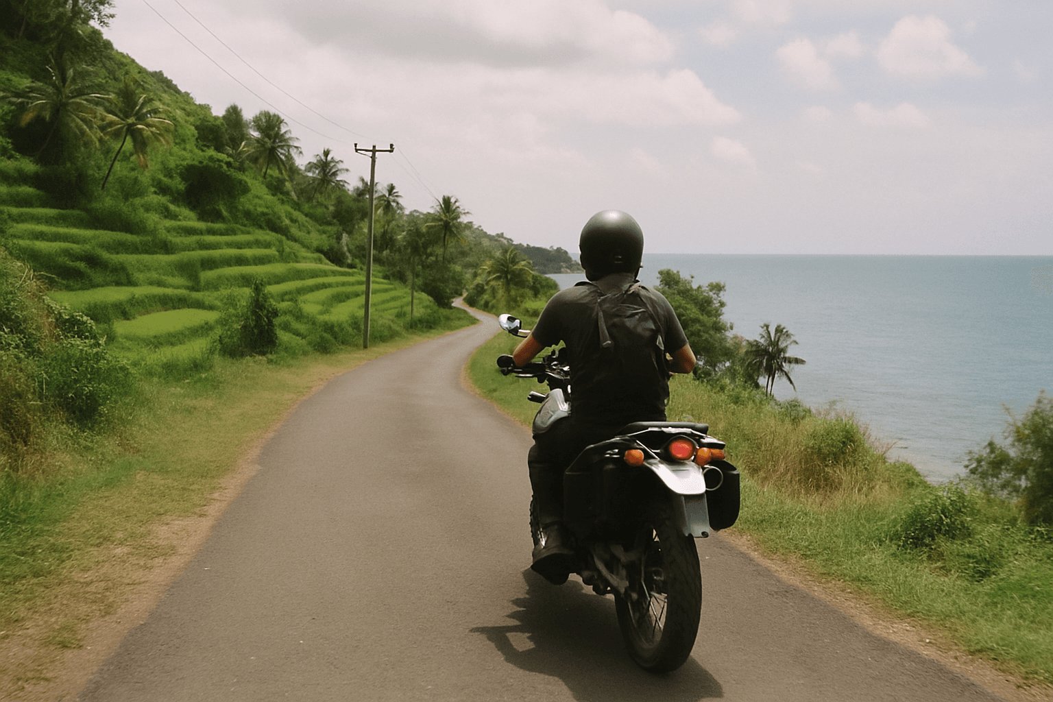 Motorcycle rider on a coastal road in Bali, Indonesia